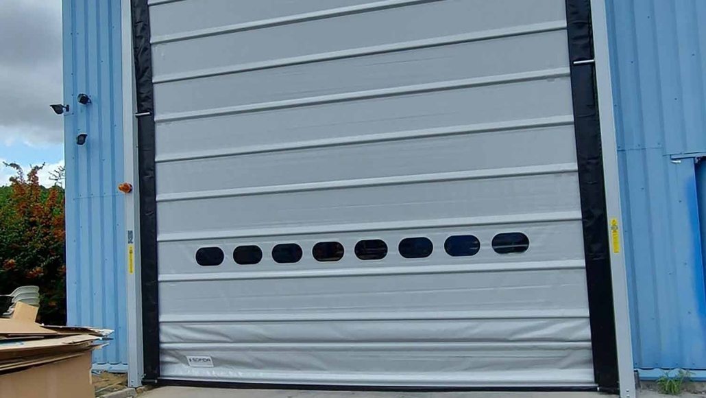 Porte souple blanche d'un entrepôt de couleur bleu ciel