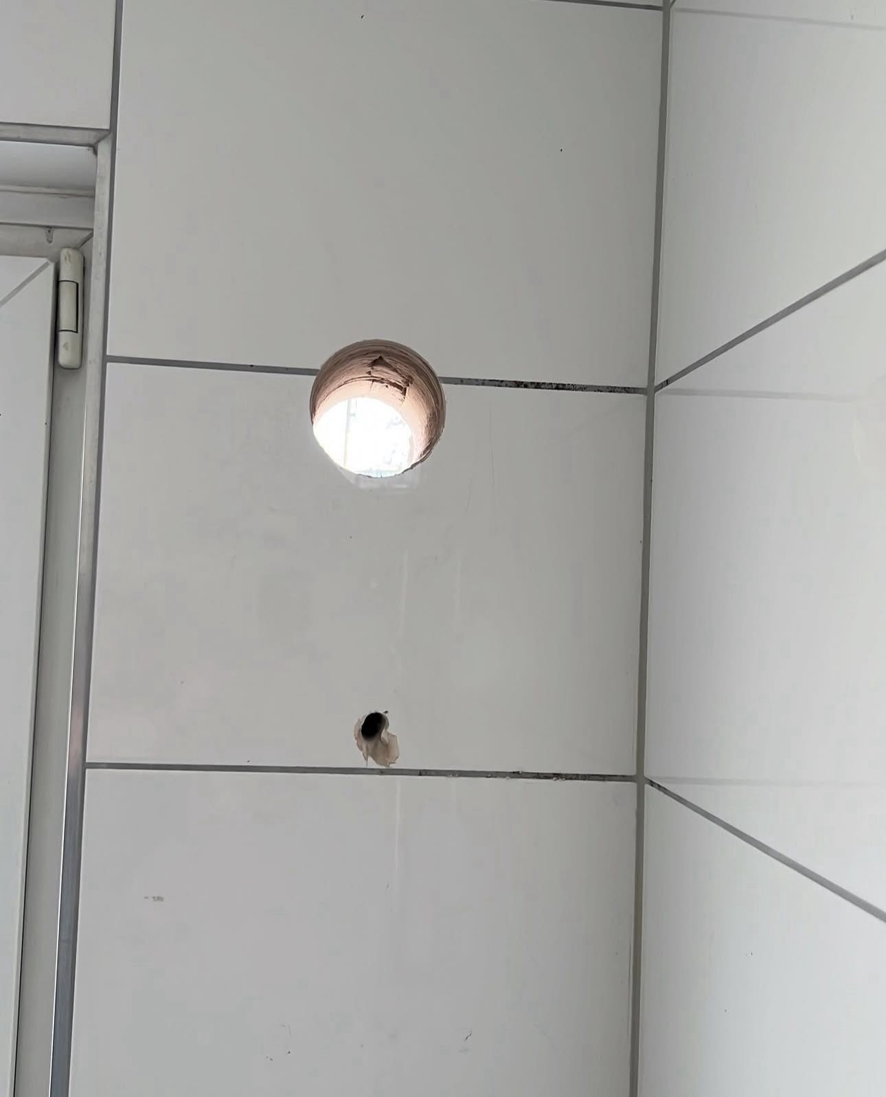 Durch ein Loch in einer Wand scheint ein Licht.