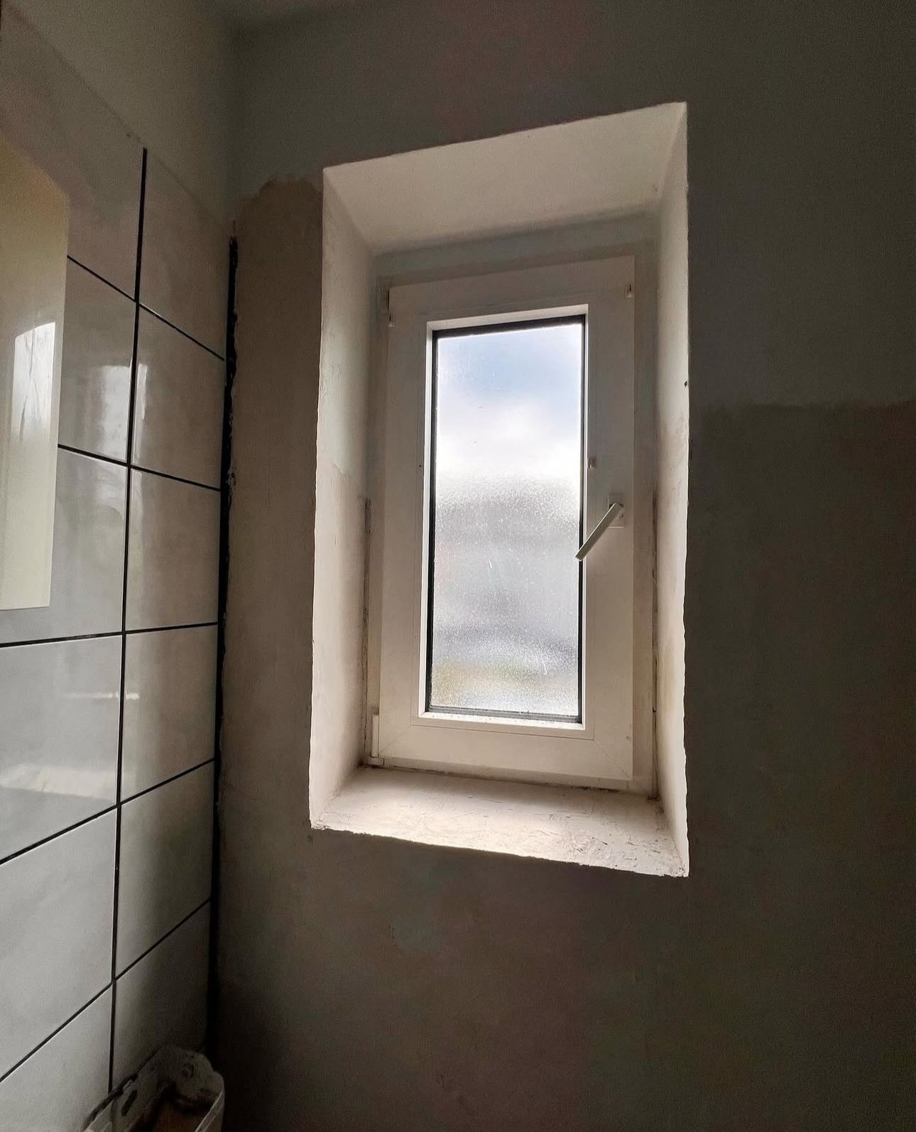 Ein Badezimmer mit Fenster und eine Toilette