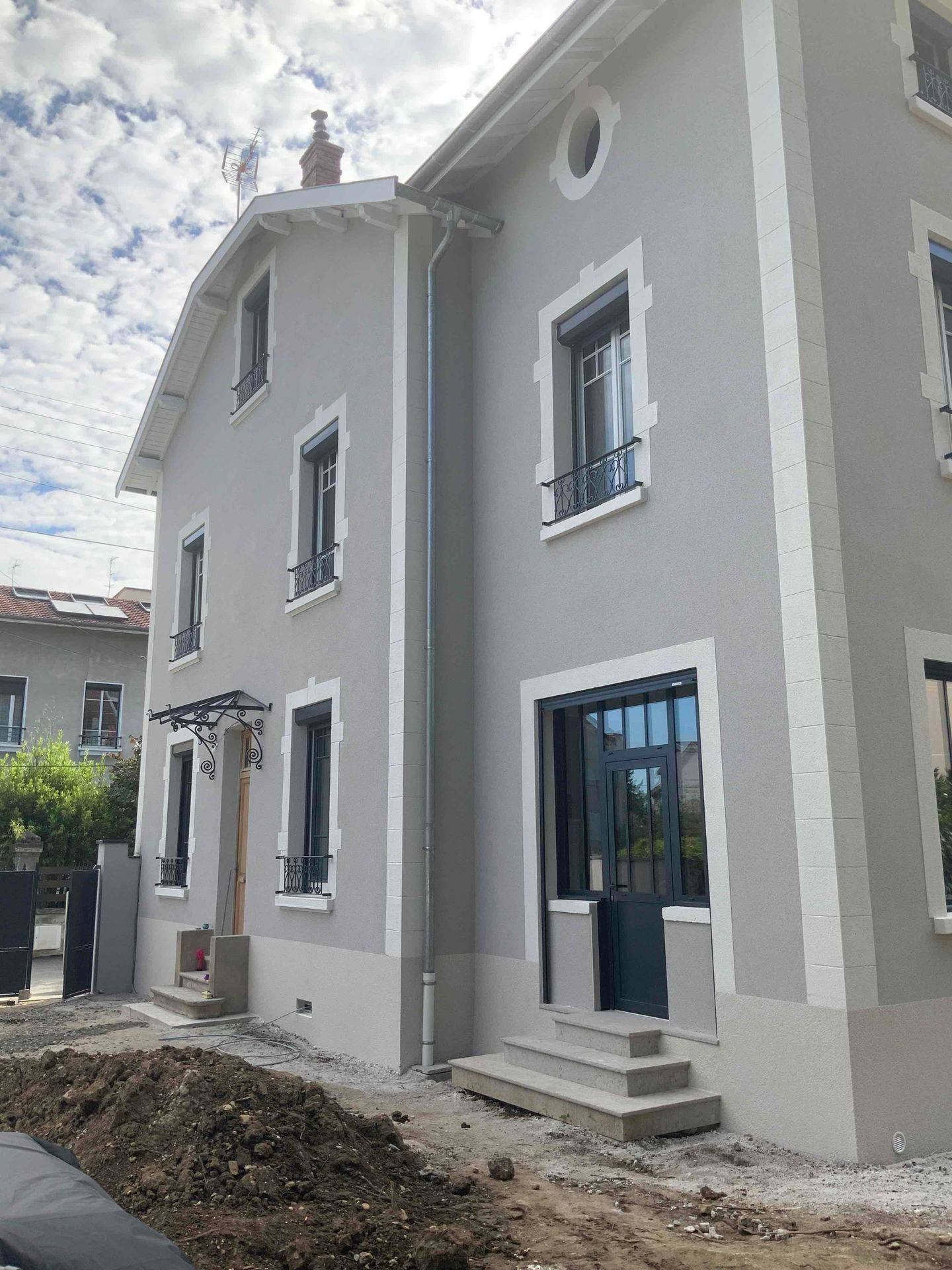 Maison avec une finition à la peinture grise en façade