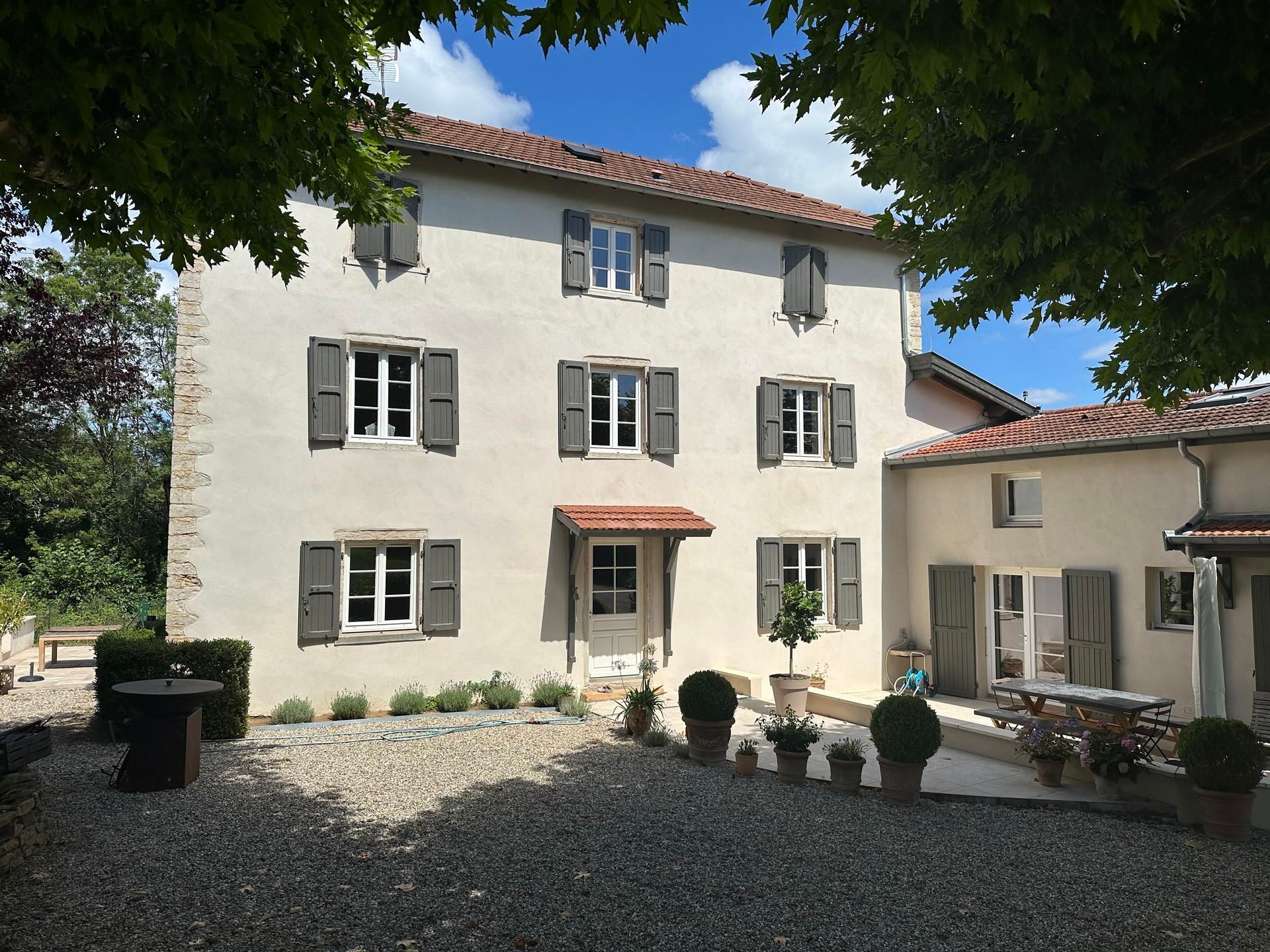 Maison avec une finition à la chaux aux volets gris