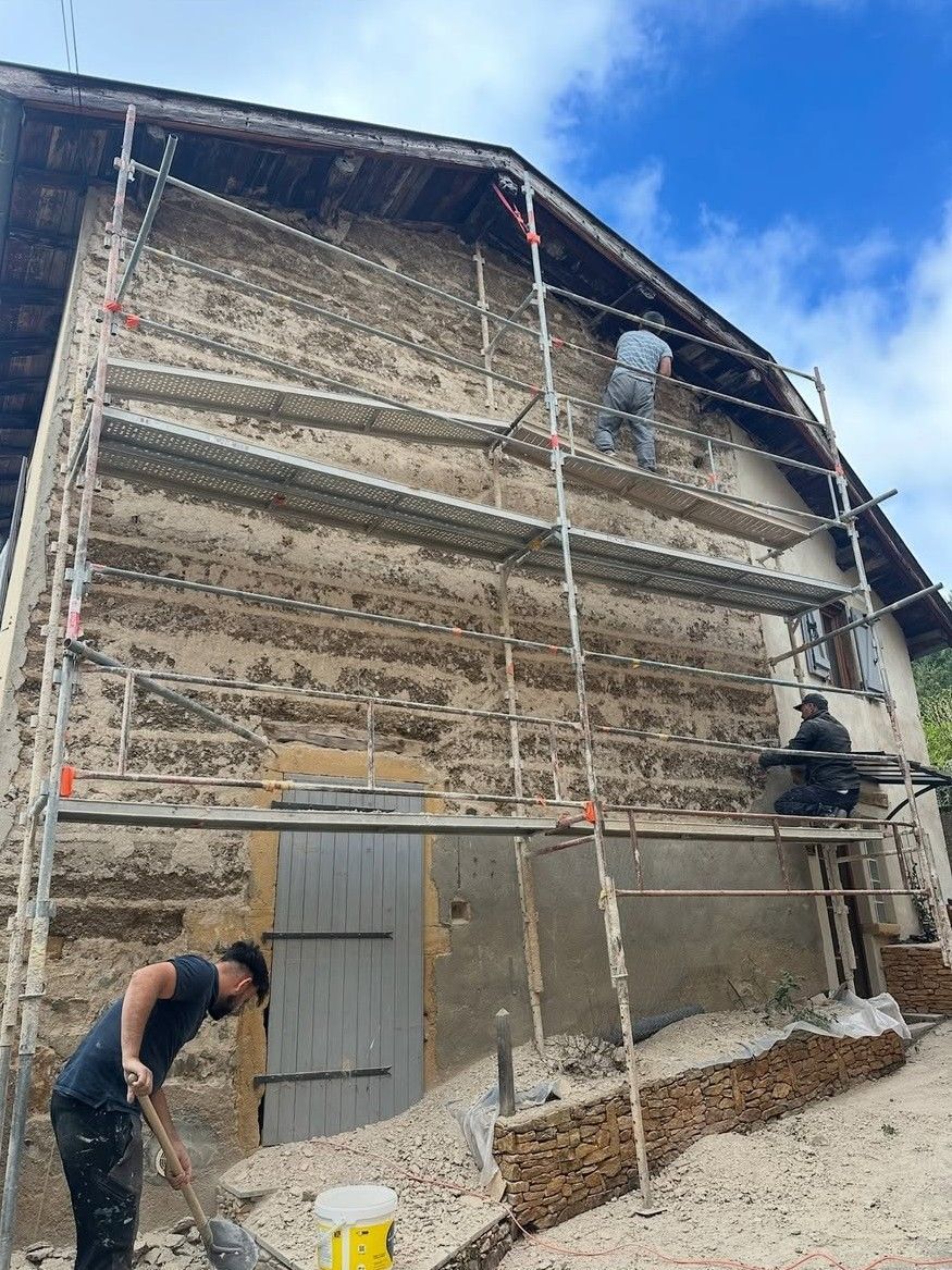 Rénovation d'une façade en pisé avec un échafaudage