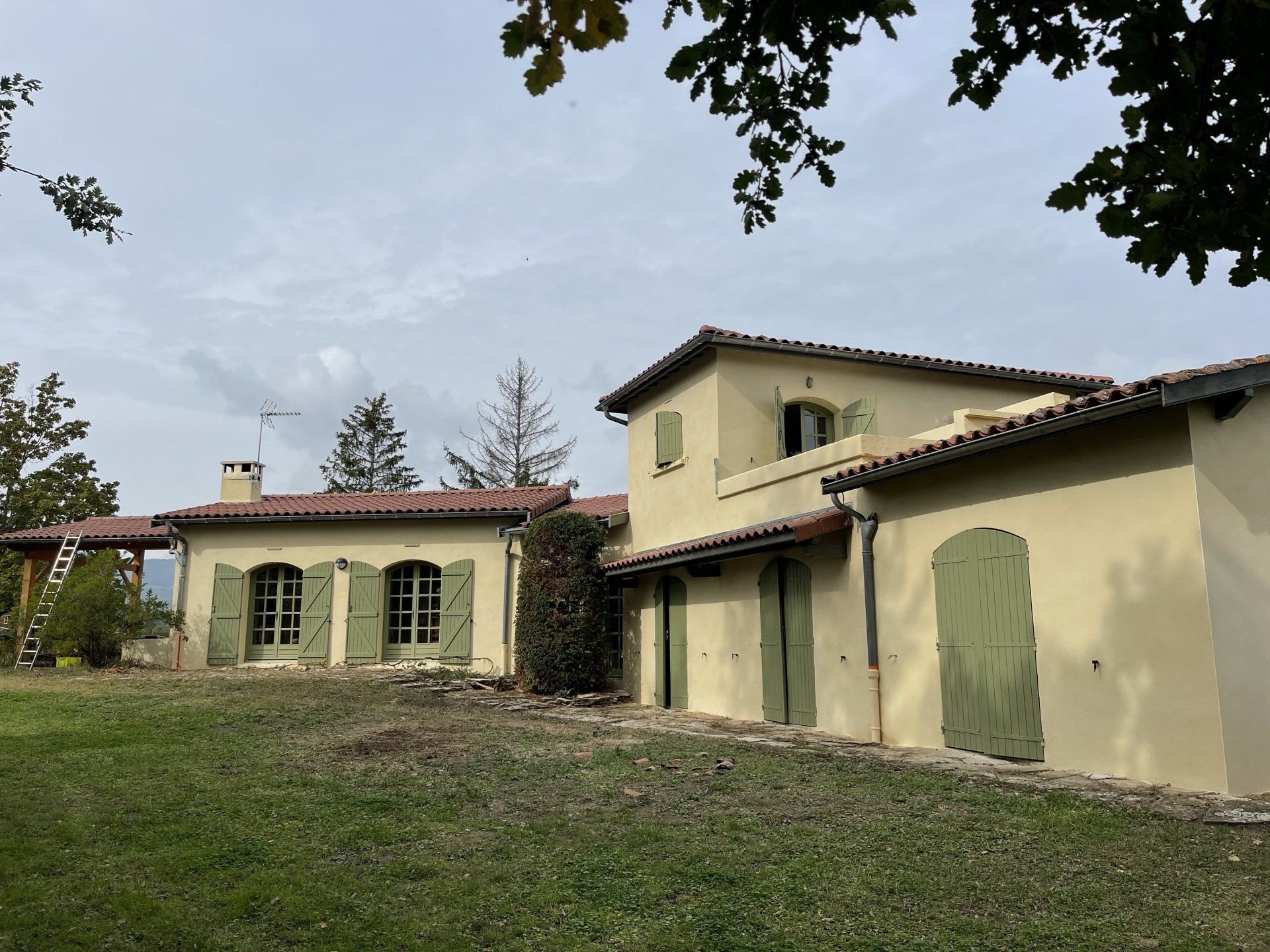 Maison jaune aux volets verts