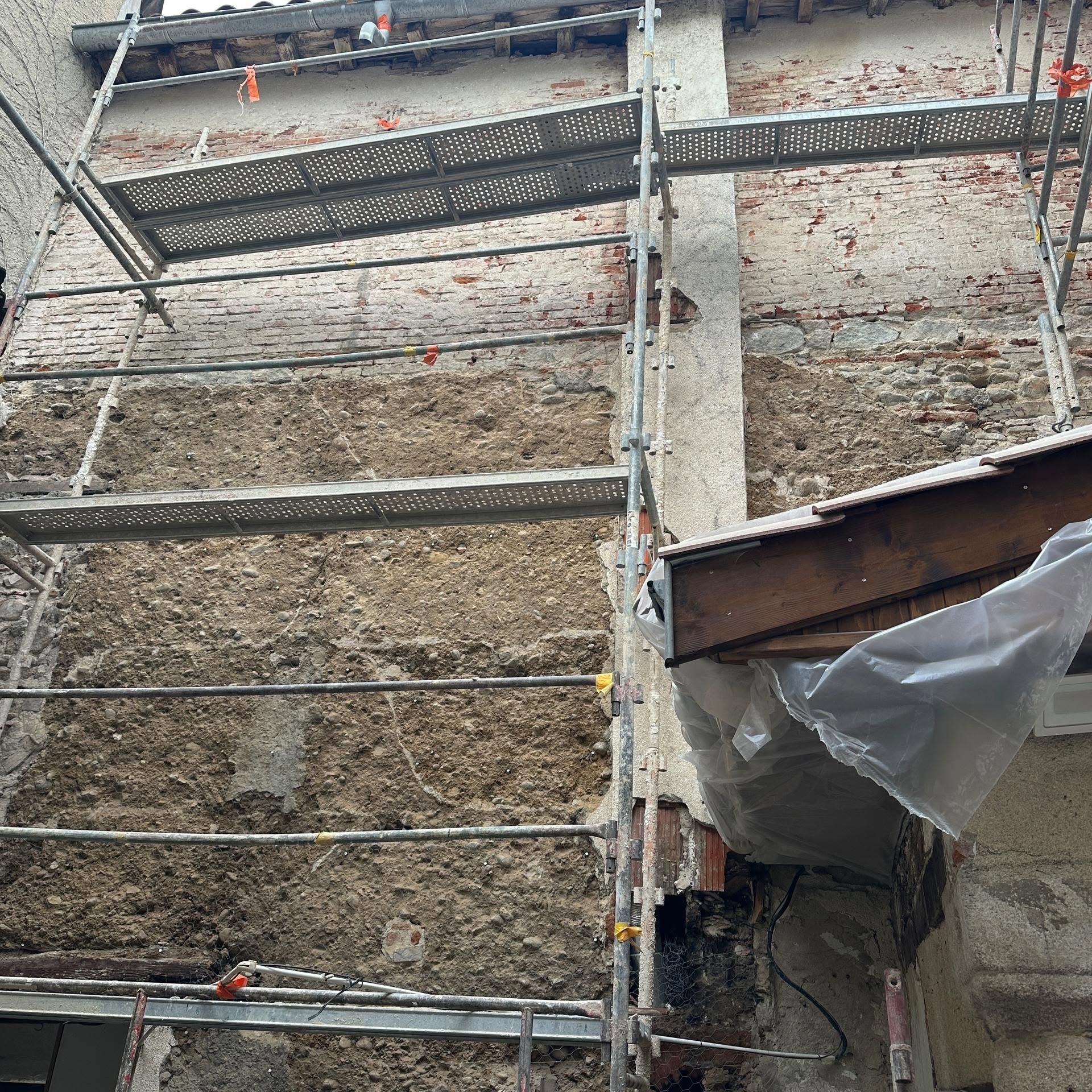 Rénovation d'une façade en pisé avec un échafaudage