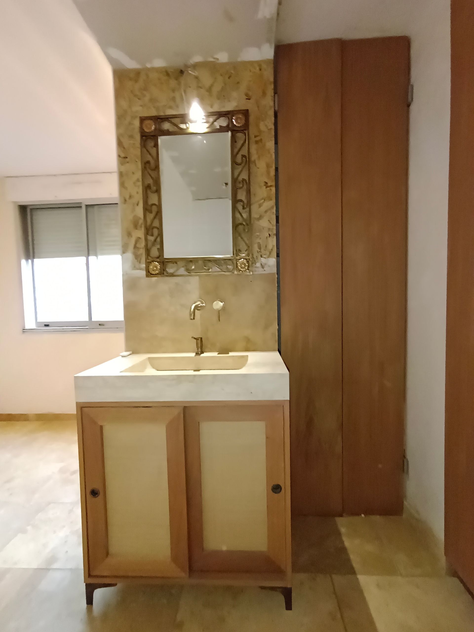 Une salle de bains avec un miroir doré.