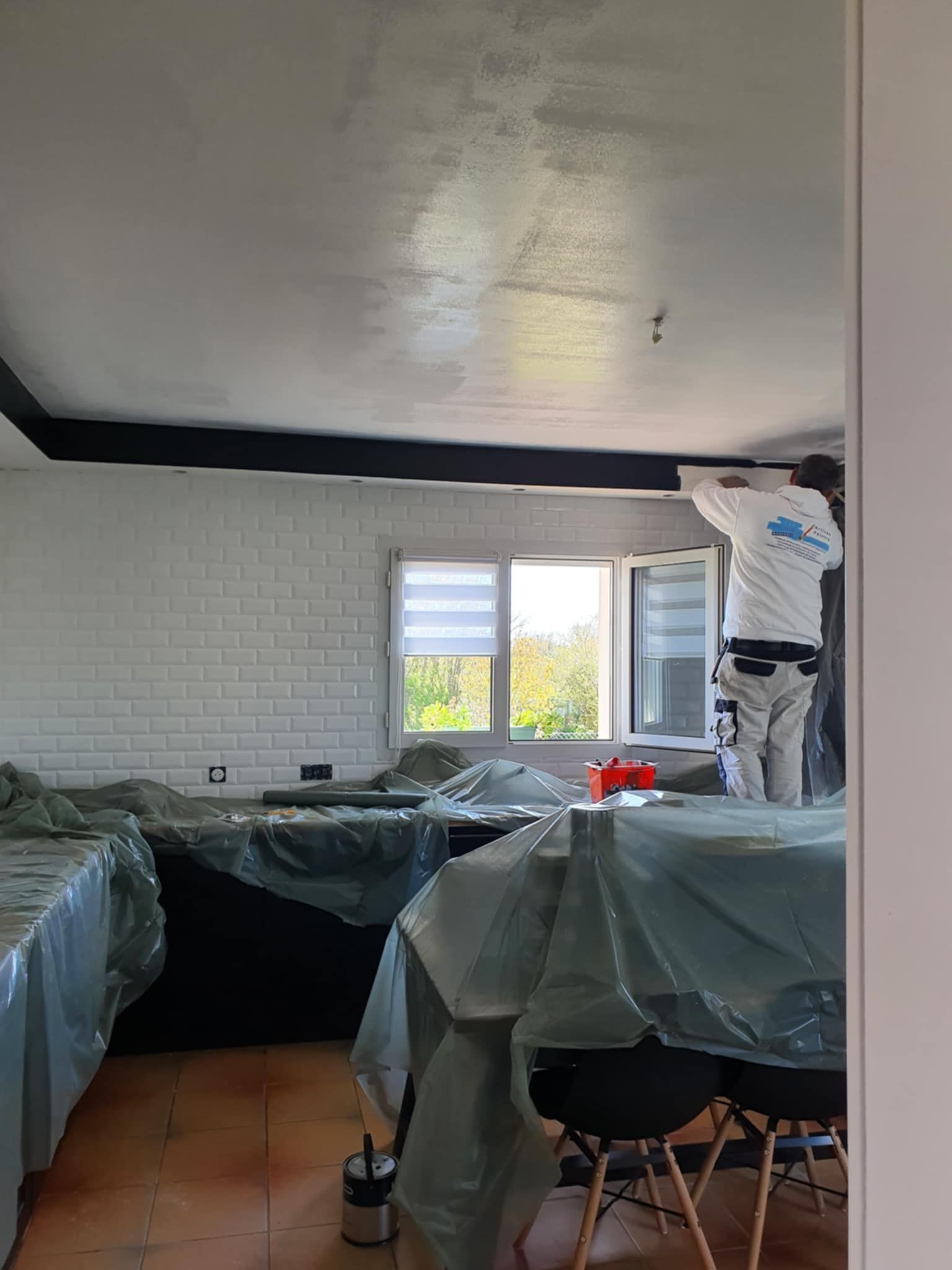 Un artisan peintre réalise la rénovation d'une cuisine