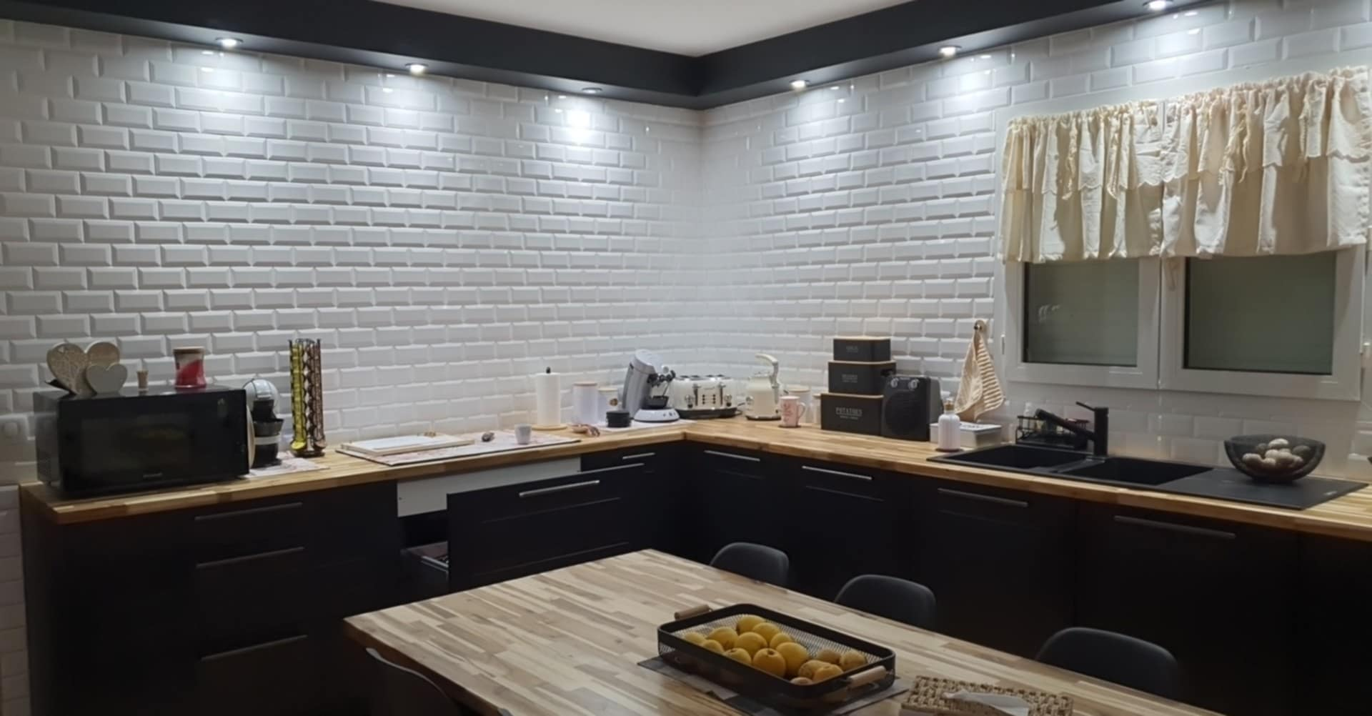 Une cuisine avec un revêtement mural imitant du carrelage