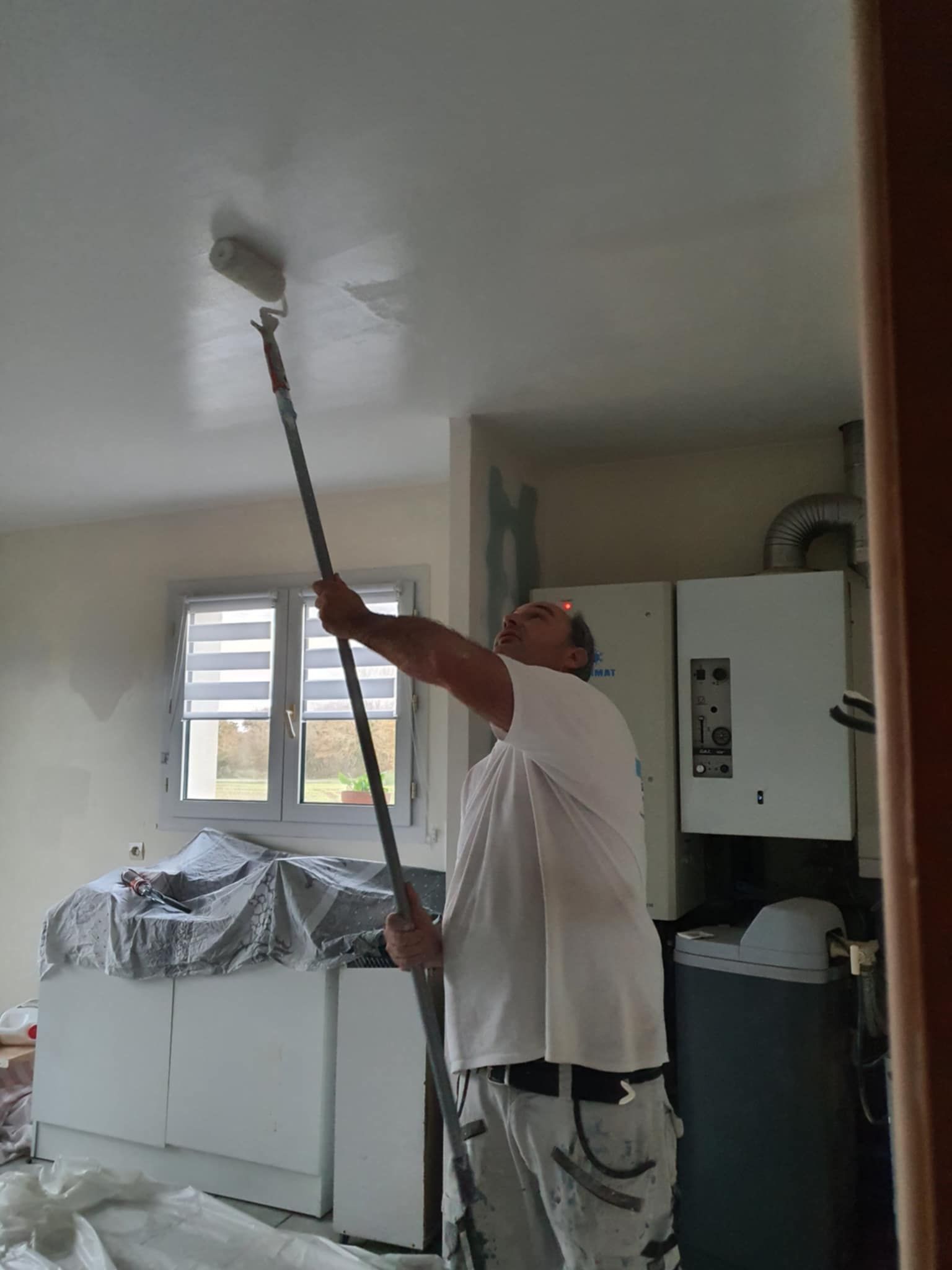 Un artisan peint un plafond