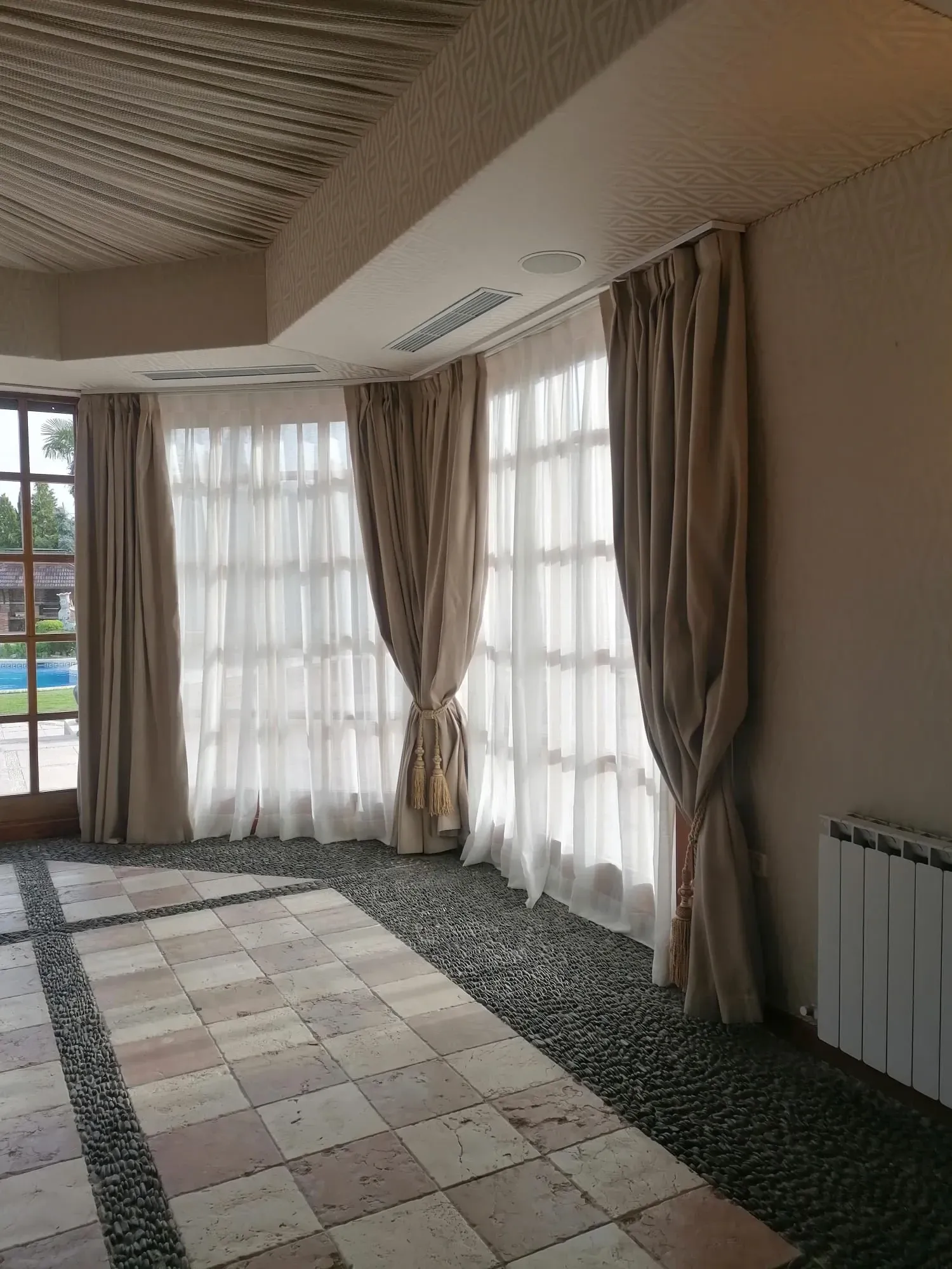 Una habitación grande con muchas ventanas y cortinas.