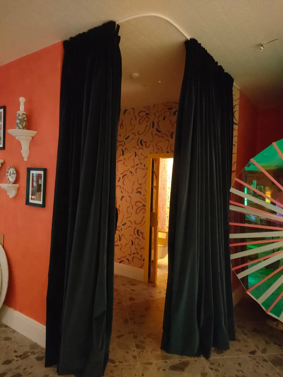 Una habitación con cortinas negras entre dos paredes.