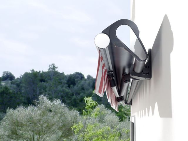 Brenig Instandsetzungs GmbH – eine rotweiße Markise im gefalteten Zustand, Bäume im Hintergrund