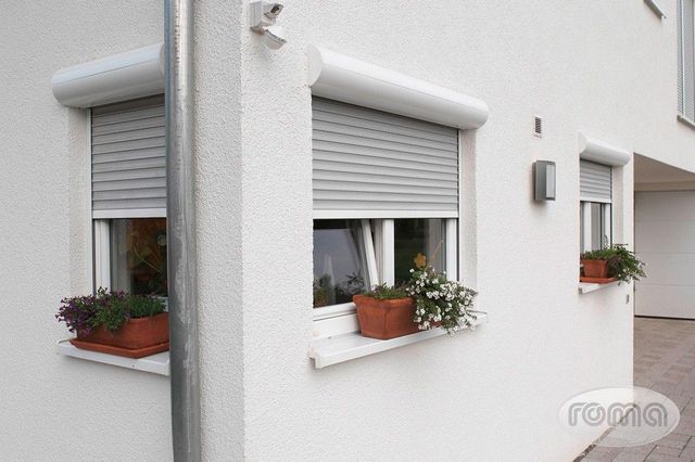 Brenig Instandsetzungs GmbH – Hausecke mit installiertem Rollladensystem an drei Fenstern