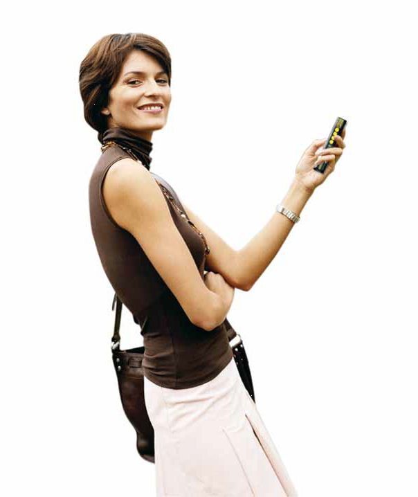 Brenig Instandsetzungs GmbH – Frau mit braunem Shirt und Handtasche vor weißem Hintergrund hält Fernsteuerung