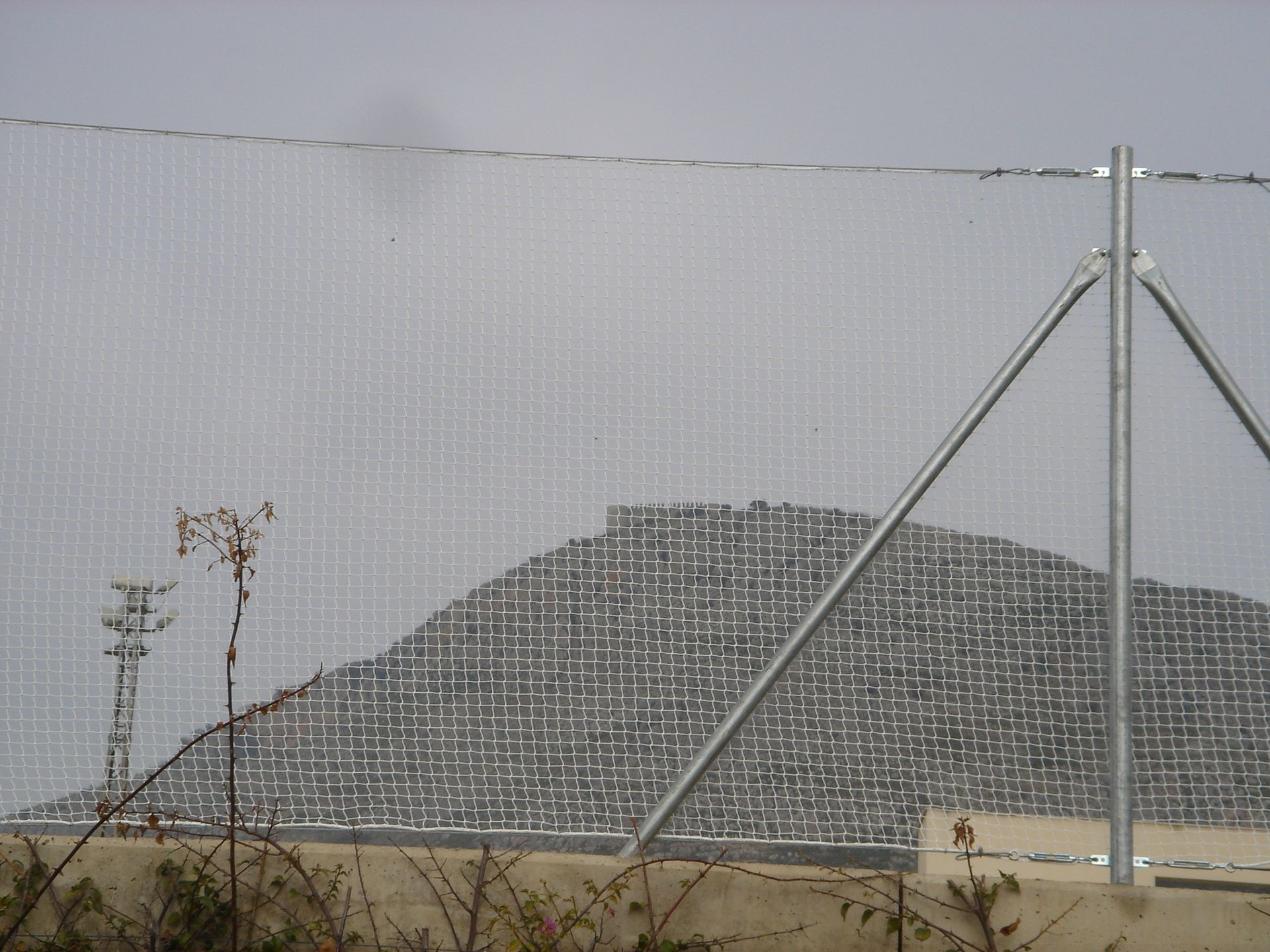 Una valla con una montaña al fondo detrás de ella.