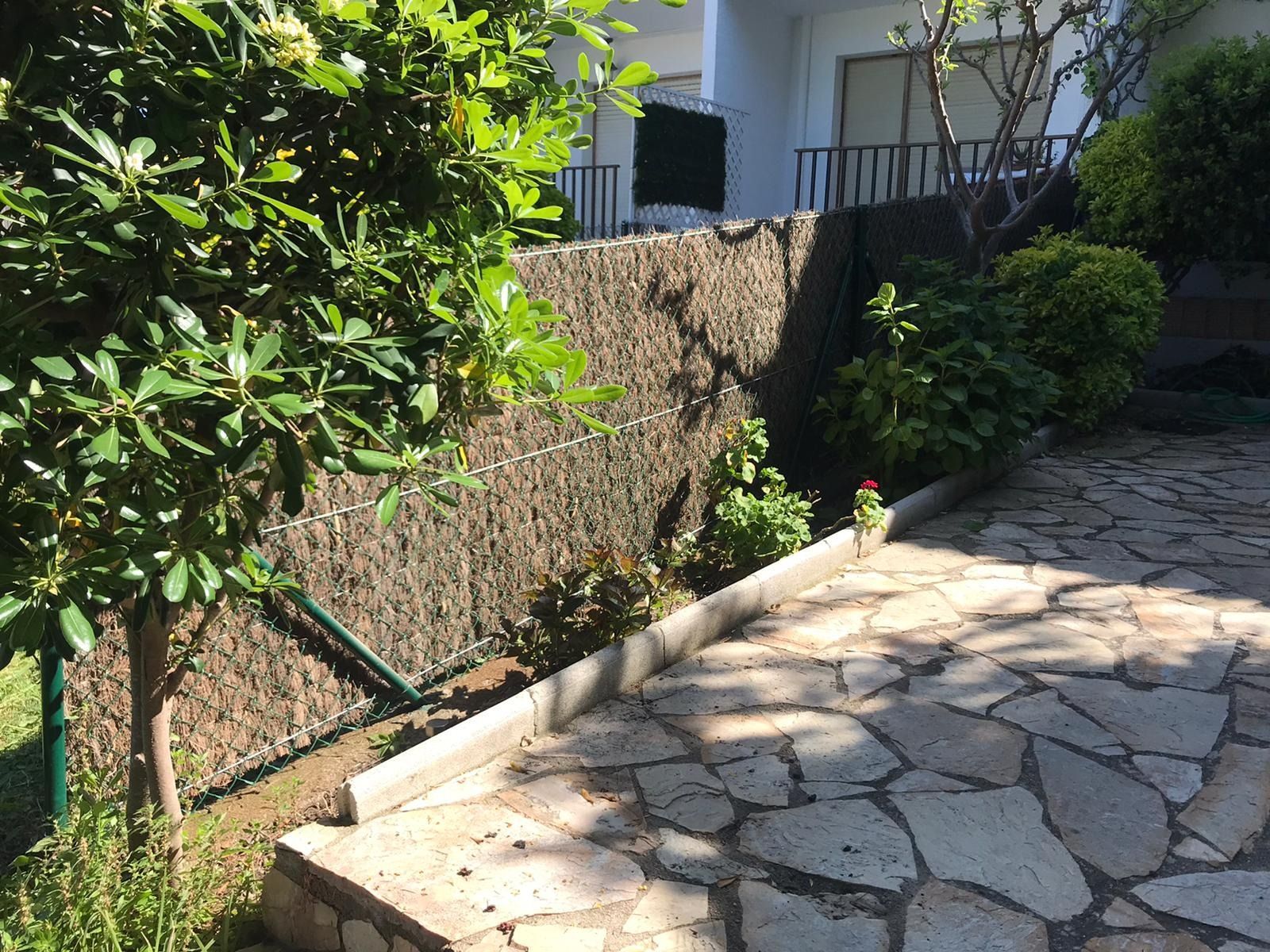 Un camino de piedra que conduce a una casa con una valla al fondo.