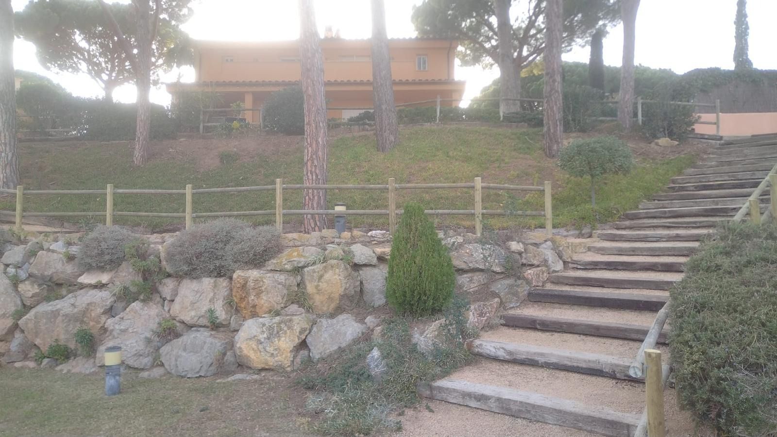 Hay escaleras que conducen a una casa al fondo.