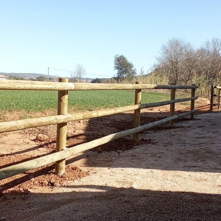 Una valla de madera con un campo al fondo