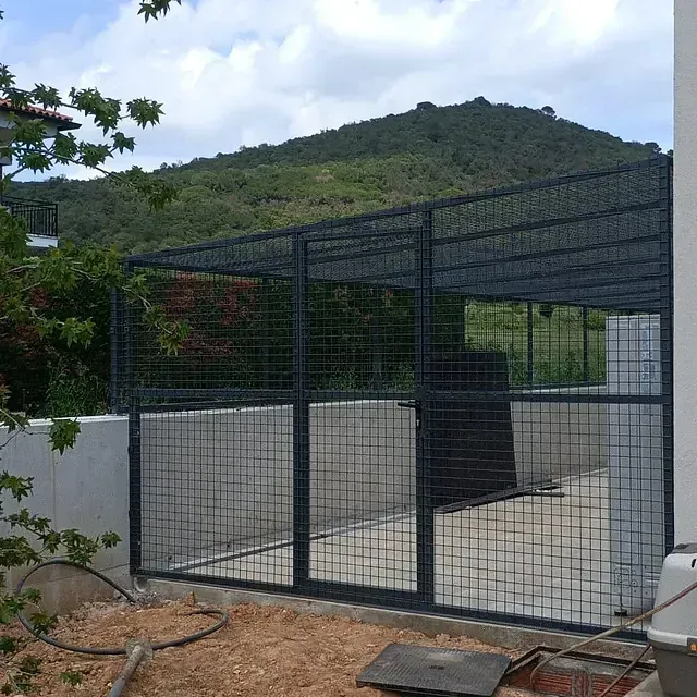 Un área vallada con una montaña al fondo.