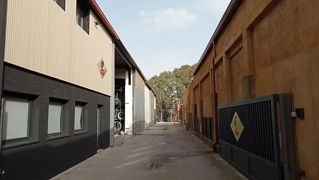 Un callejón estrecho entre dos edificios con una puerta en el medio.