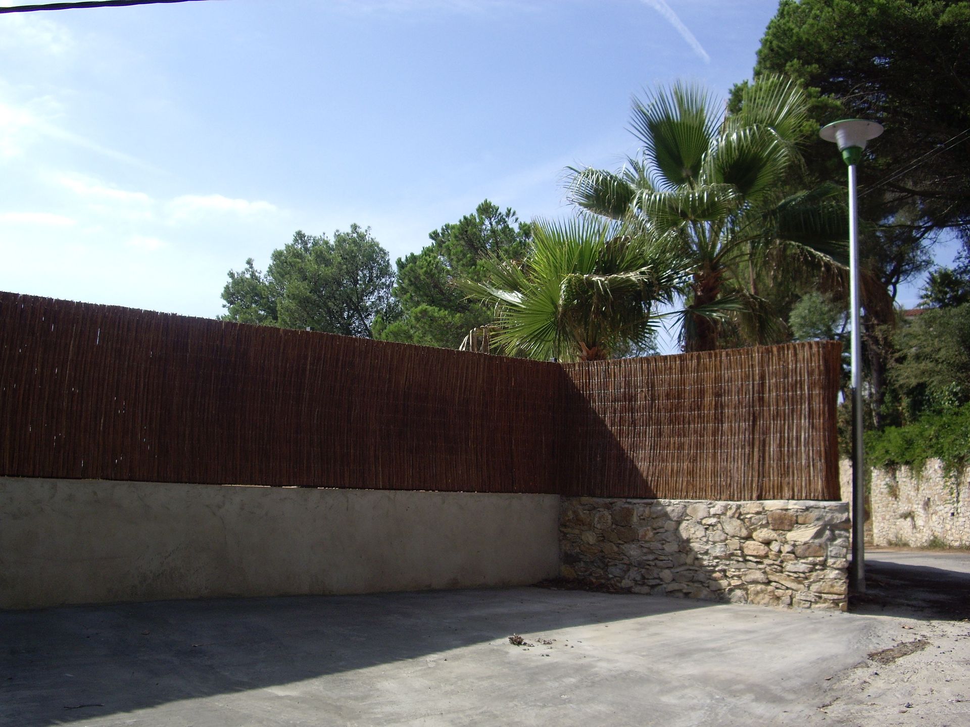 Una valla con una palmera al fondo