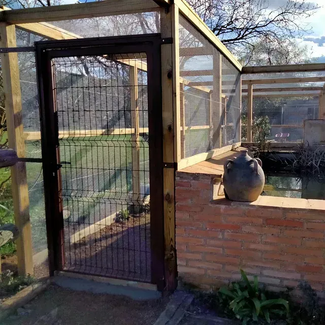 Un área cercada con un muro de ladrillo y una puerta.