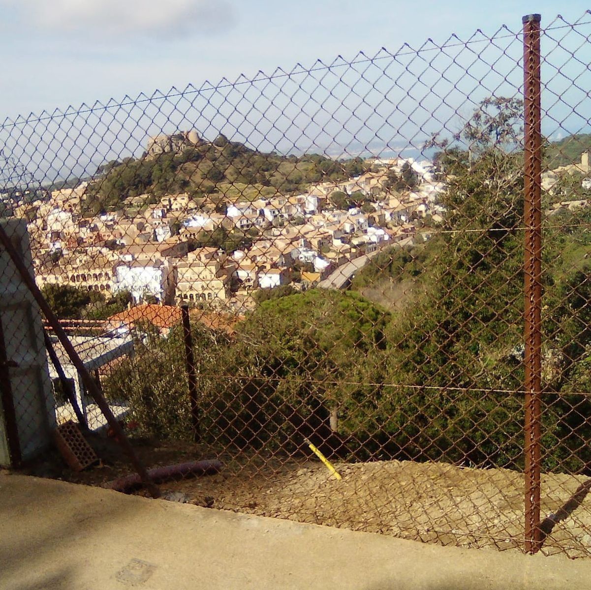 Una valla de alambre con una ciudad al fondo