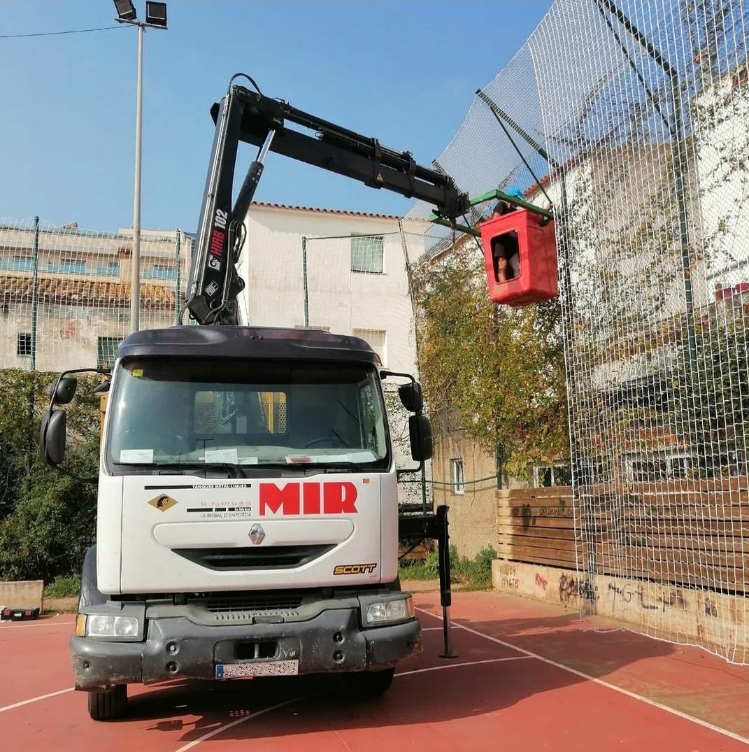 Un camión Mir está estacionado en una cancha de baloncesto.