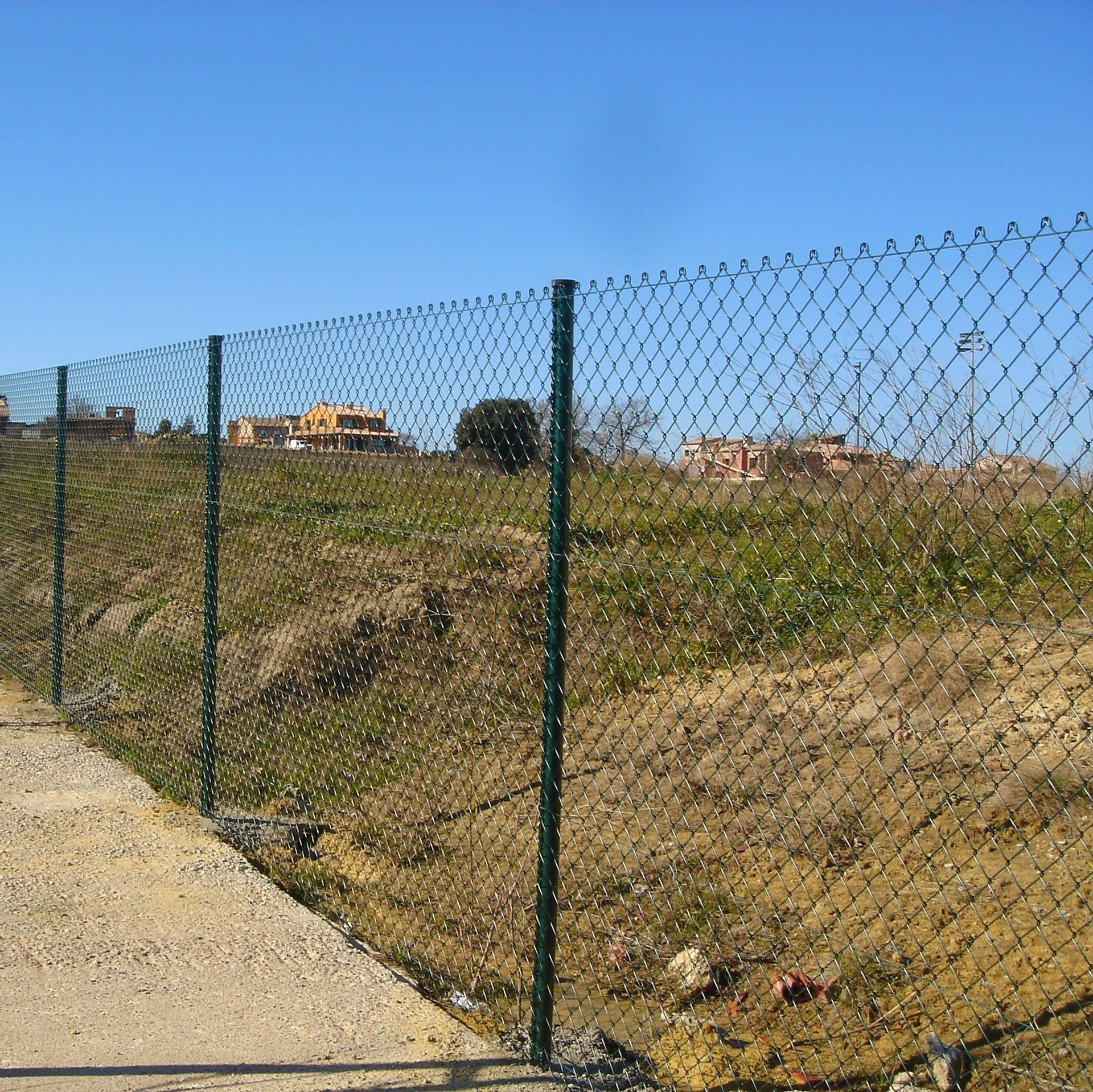 Una valla de alambre a lo largo de un camino de tierra