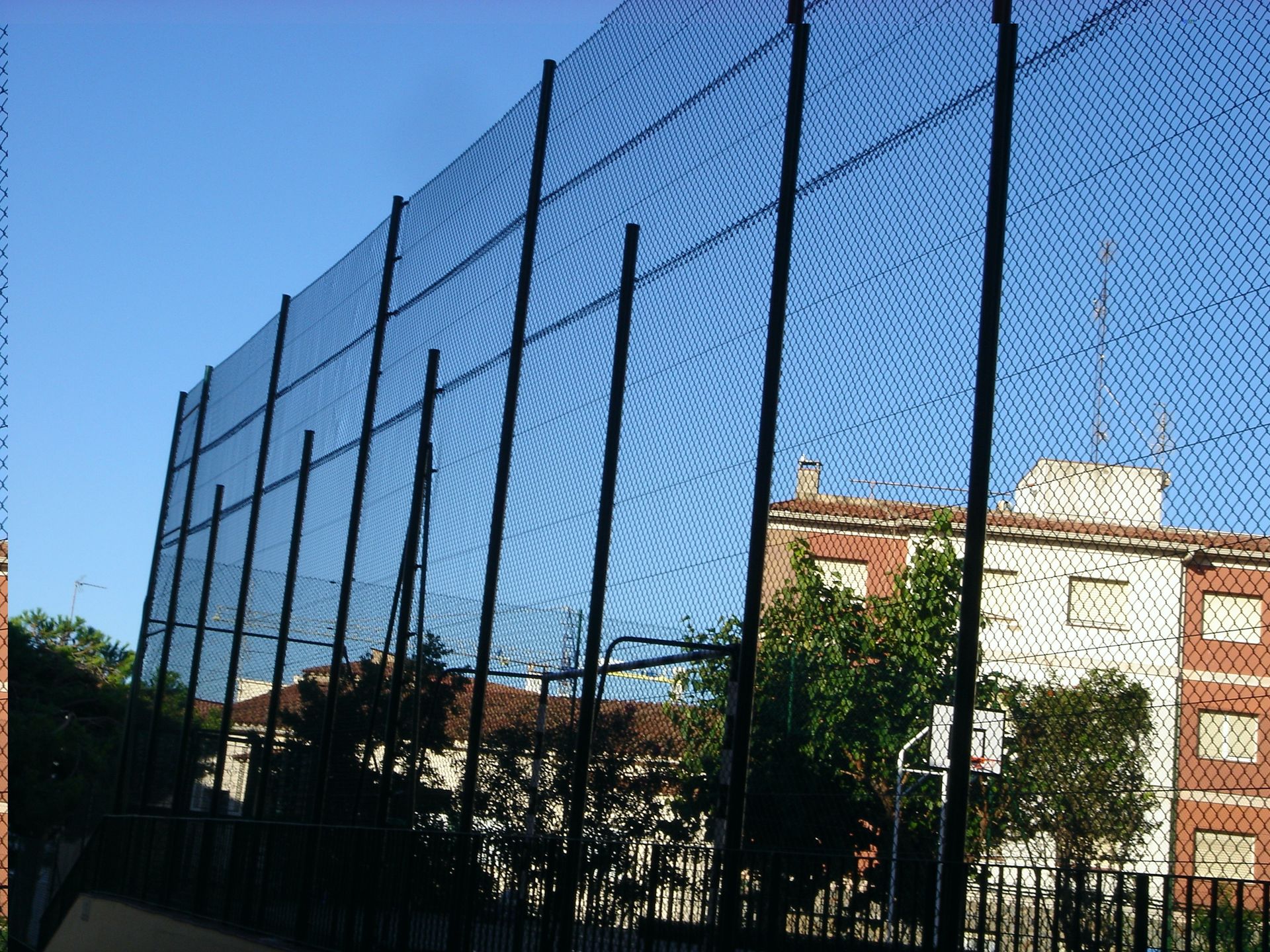 Una valla de alambre con un edificio de ladrillo al fondo
