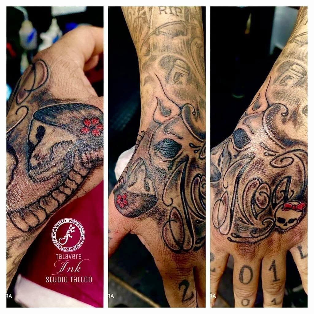 Diseño de tatuaje de tres paneles en la mano y el antebrazo, en negro y gris con detalles rojos