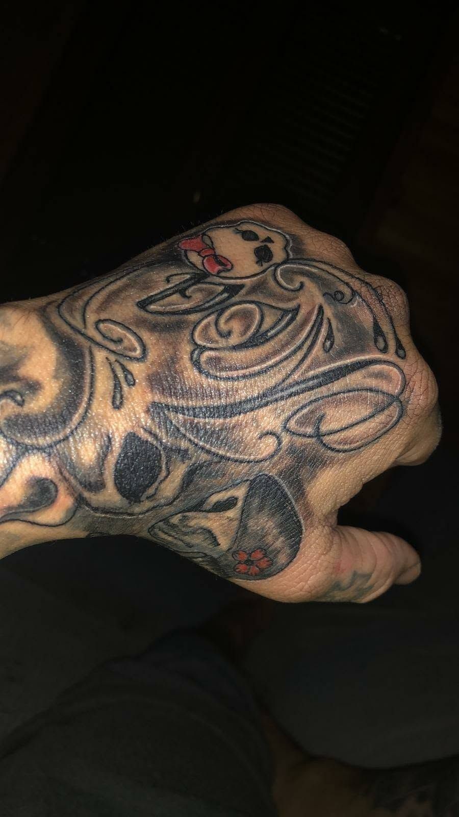Primer plano de una mano tatuada, con patrones de tinta negra y gris oscuro en los nudillos y el dorso de la mano