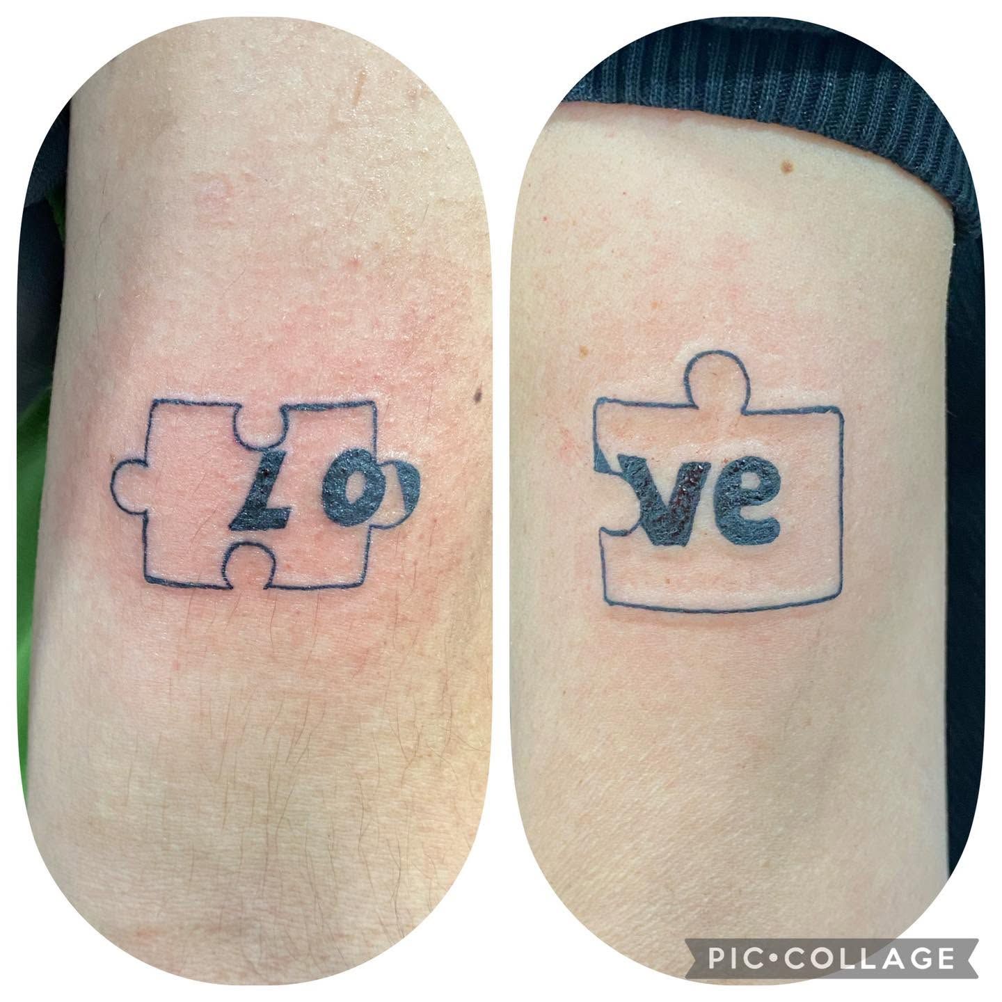 Dos tatuajes en las muñecas con piezas de rompecabezas que forman la palabra «love» en tinta azul de contorno.