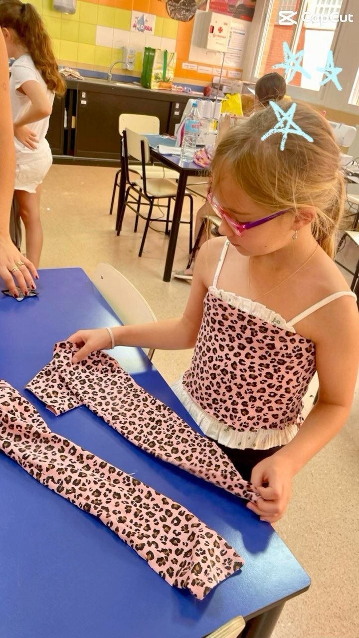 Una niña está sentada en una mesa con una camisa con estampado de leopardo.