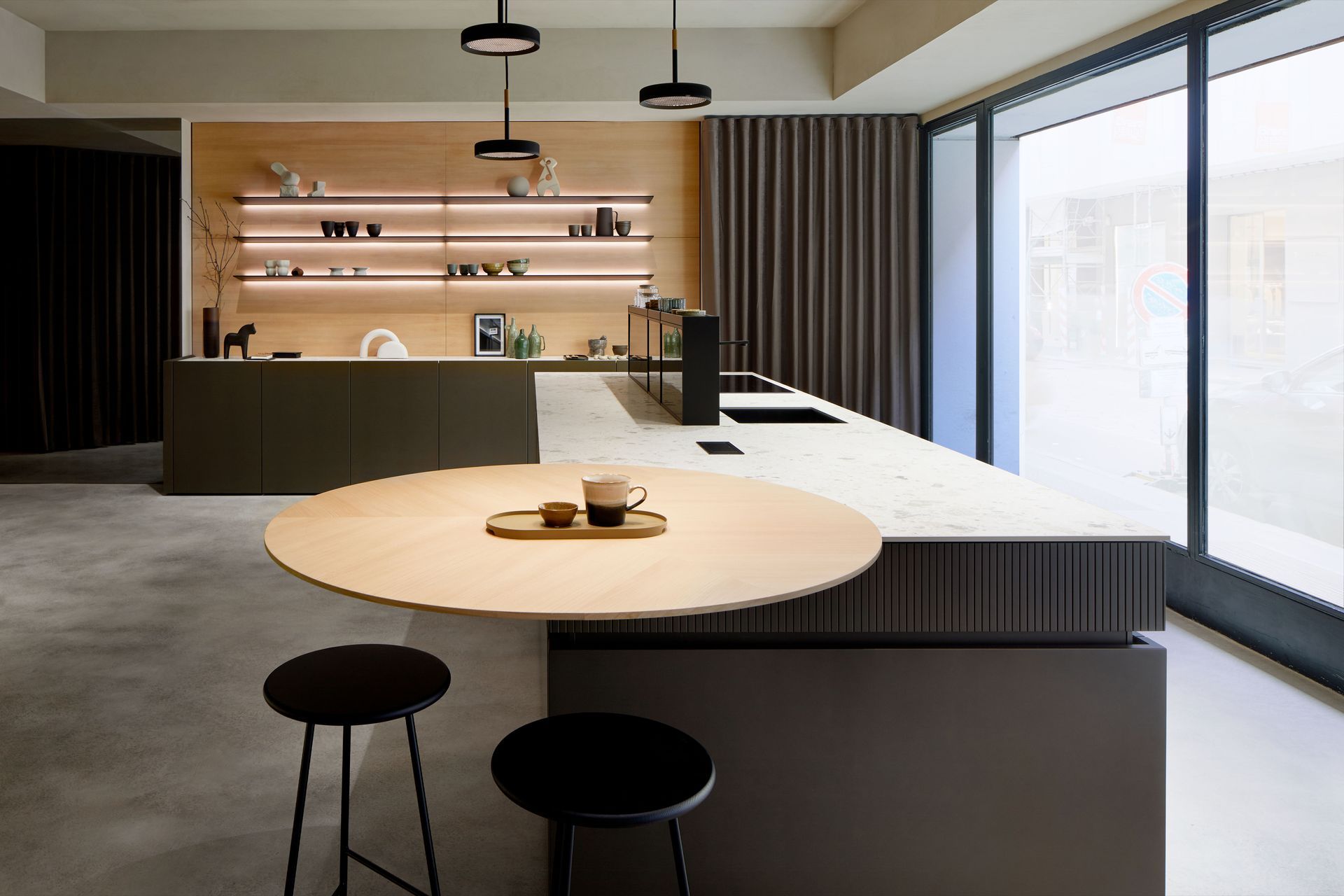 Cuisine moderne avec placards en bois chaleureux, électroménager en inox et lumière naturelle grâce à une fenêtre.