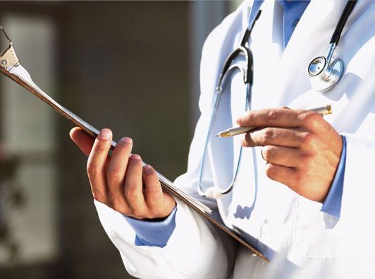 Un médico sostiene un portapapeles y un bolígrafo.