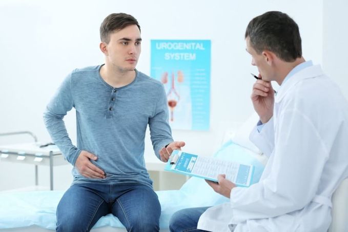 Un hombre está sentado en una cama hablando con un médico.
