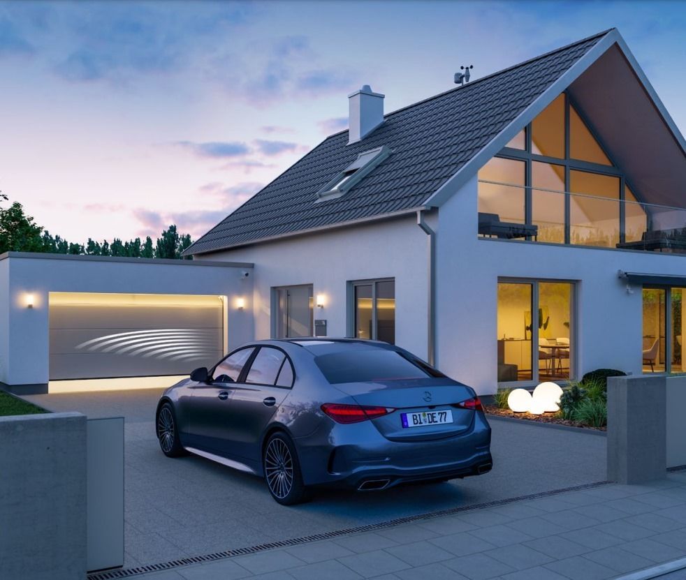 Un coche azul está aparcado delante de una casa blanca.