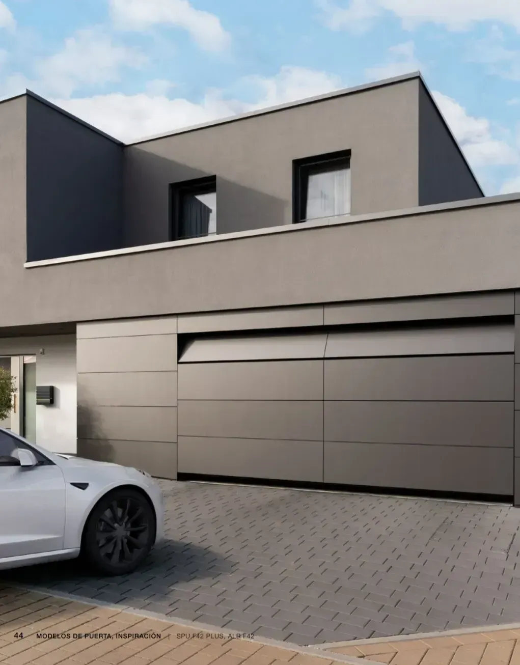 Un coche blanco está aparcado delante de una casa grande.