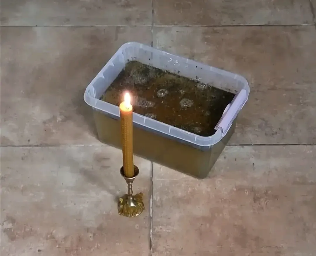 Una vela amarilla encendida en un candelabro de latón