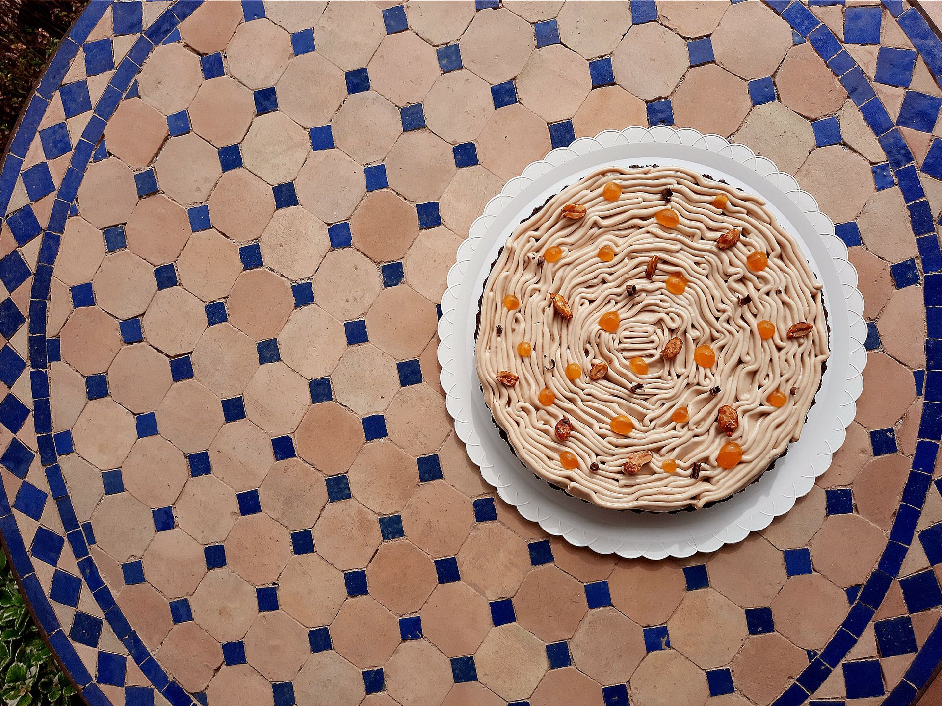 Un plato de fideos con guarnición de naranja sobre un mantel estampado azul y beige.