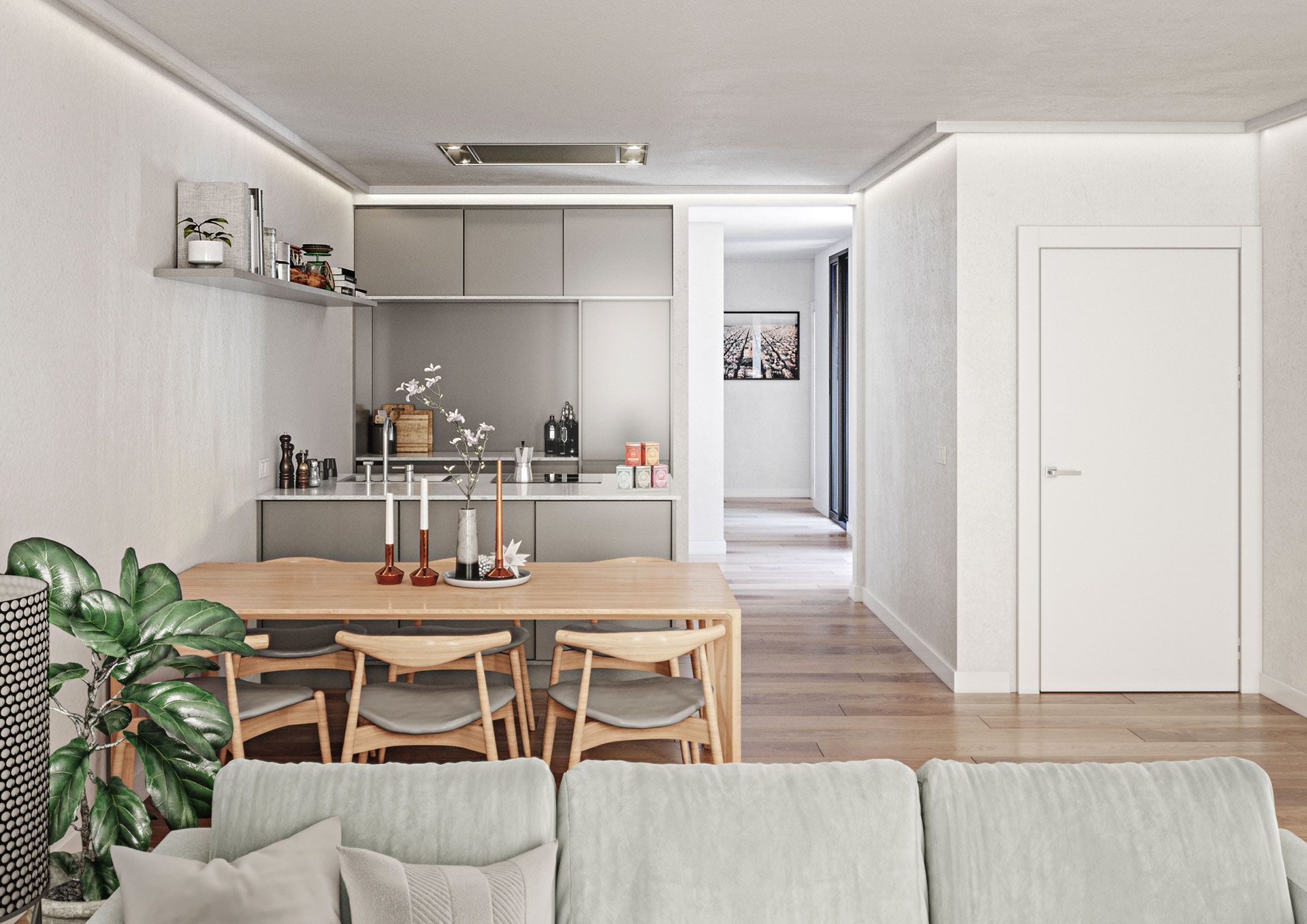 Una sala de estar con un sofá, mesa y sillas y una cocina al fondo.