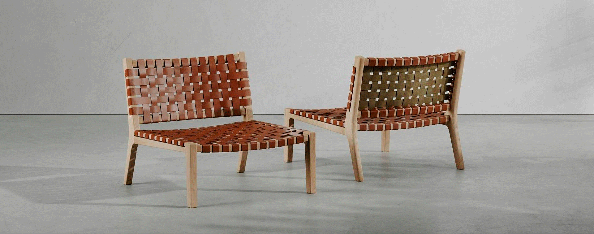 Dos sillas de cuero marrón están una al lado de la otra sobre un piso de concreto.