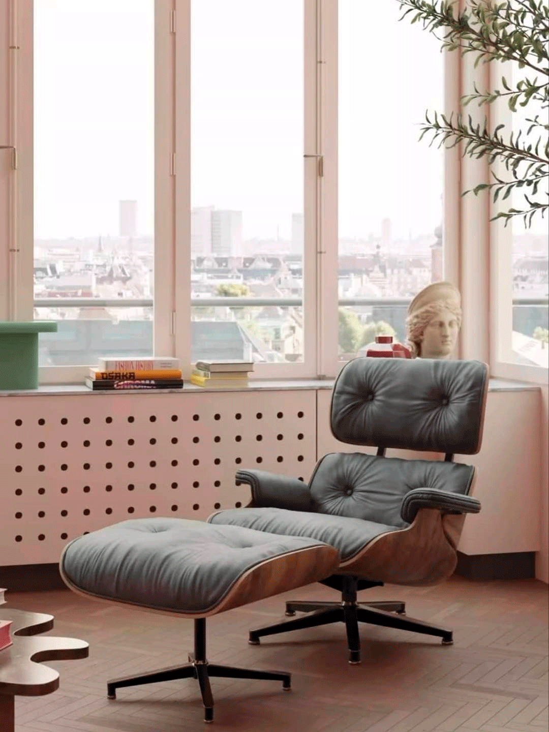 Una silla y una otomana están en una sala de estar al lado de una ventana.