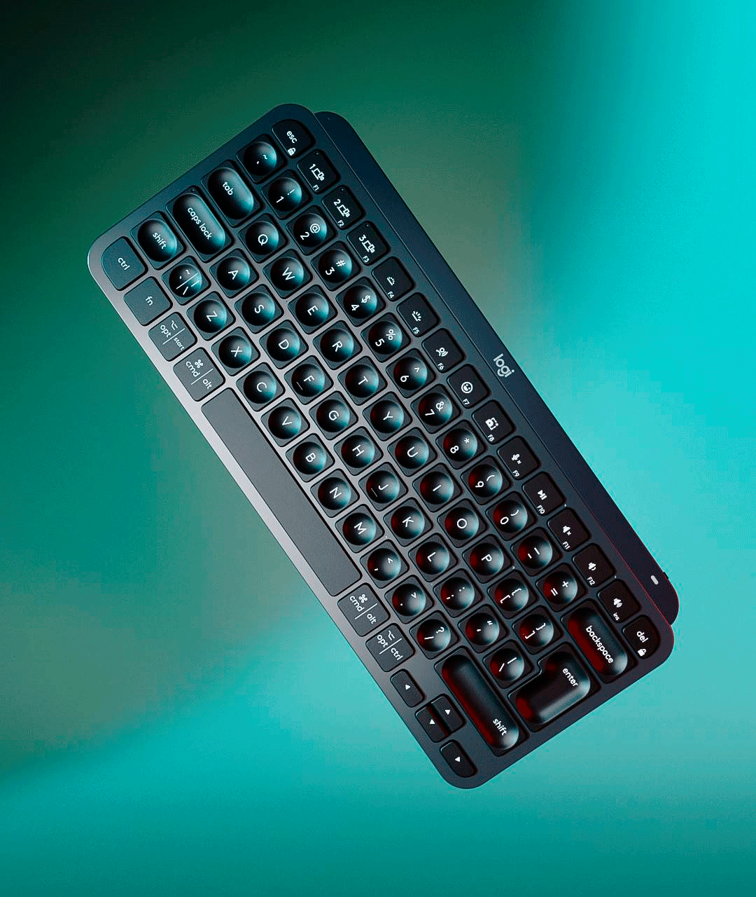 Un teclado negro está sobre una superficie azul.