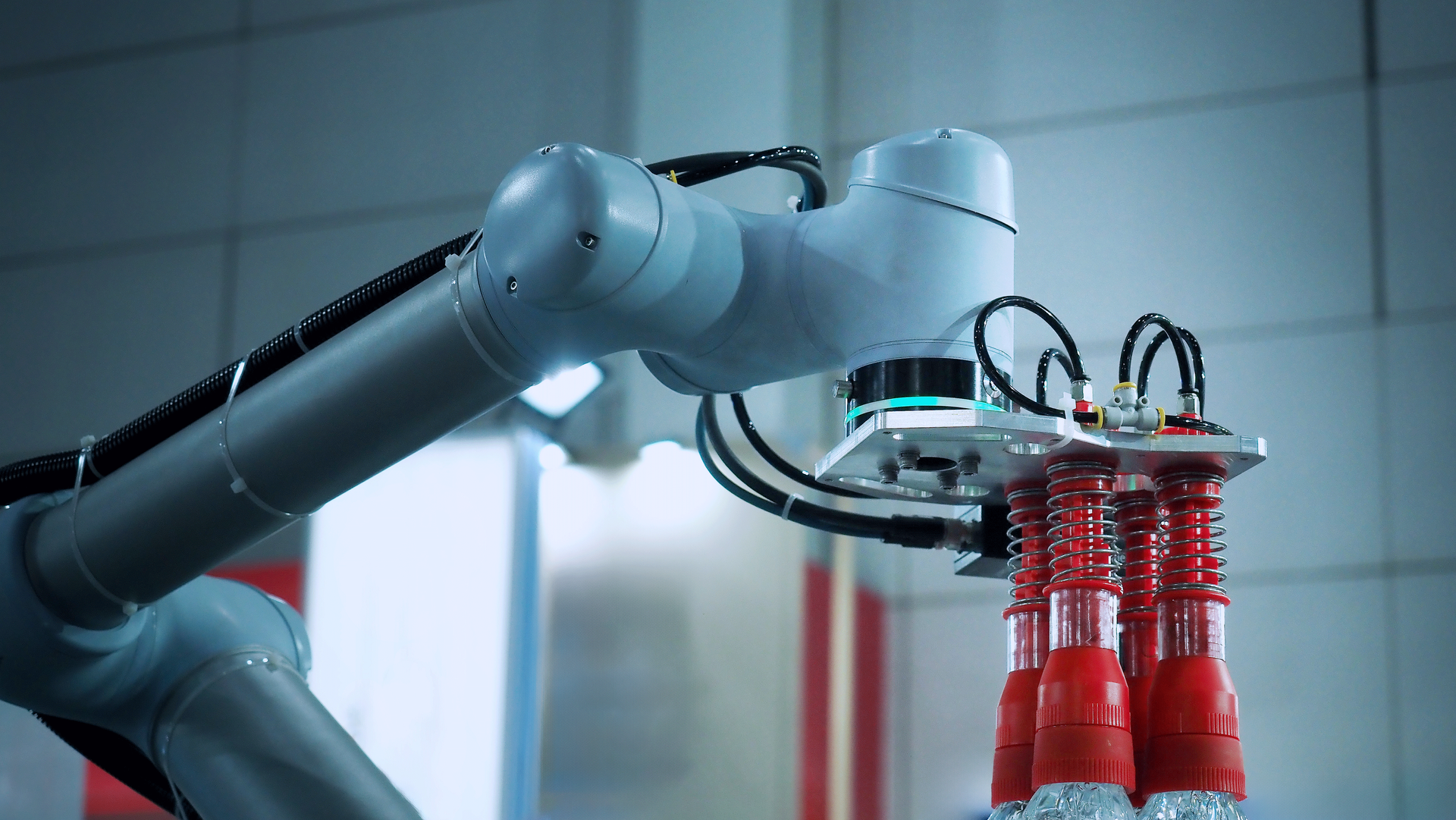 Un brazo robótico está recogiendo botellas en una fábrica.