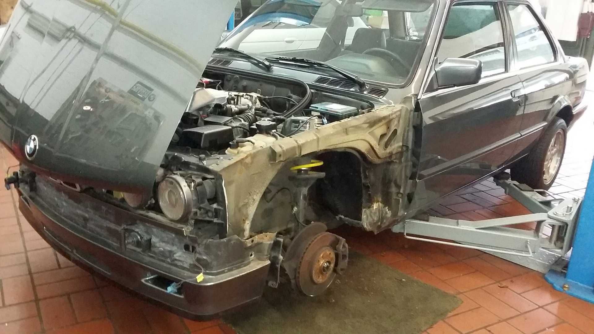 Ein Auto mit offener Motorhaube steht auf einem gefliesten Boden