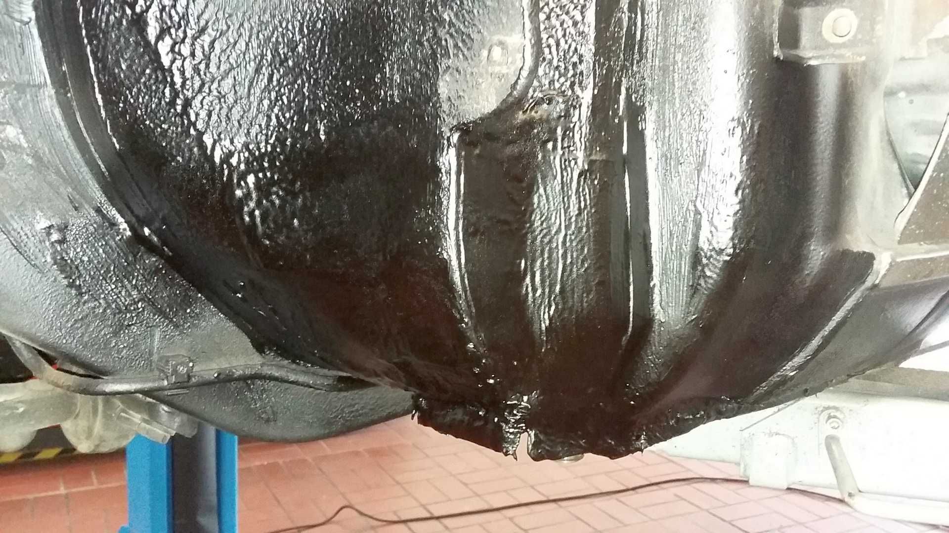 Die Unterseite eines Autos ist mit schwarzer Farbe bedeckt.