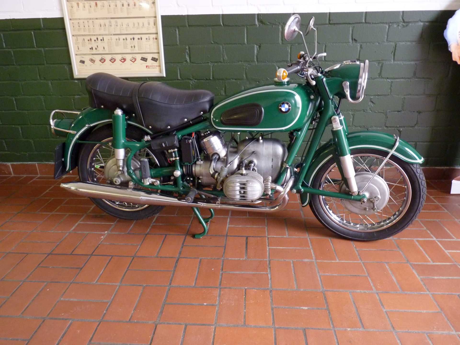 Ein grünes Motorrad ist auf einem gefliesten Boden geparkt