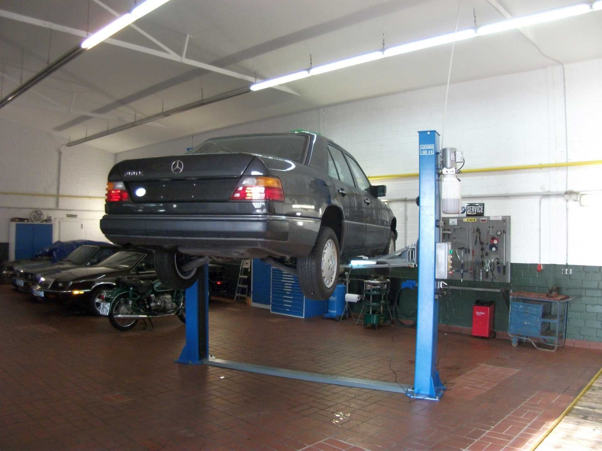 Ein Mercedes steht auf einer Hebebühne in einer Garage