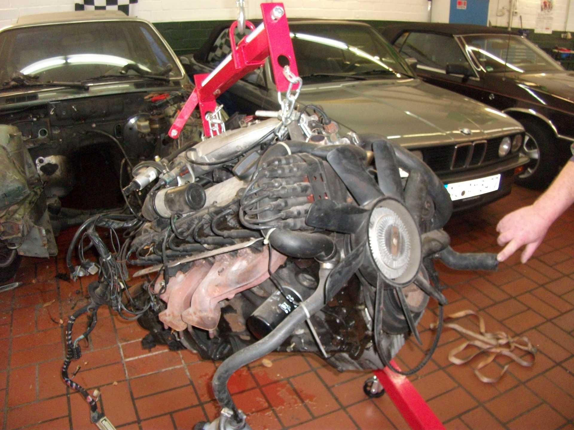 In einer Garage wird an einem Automotor gearbeitet